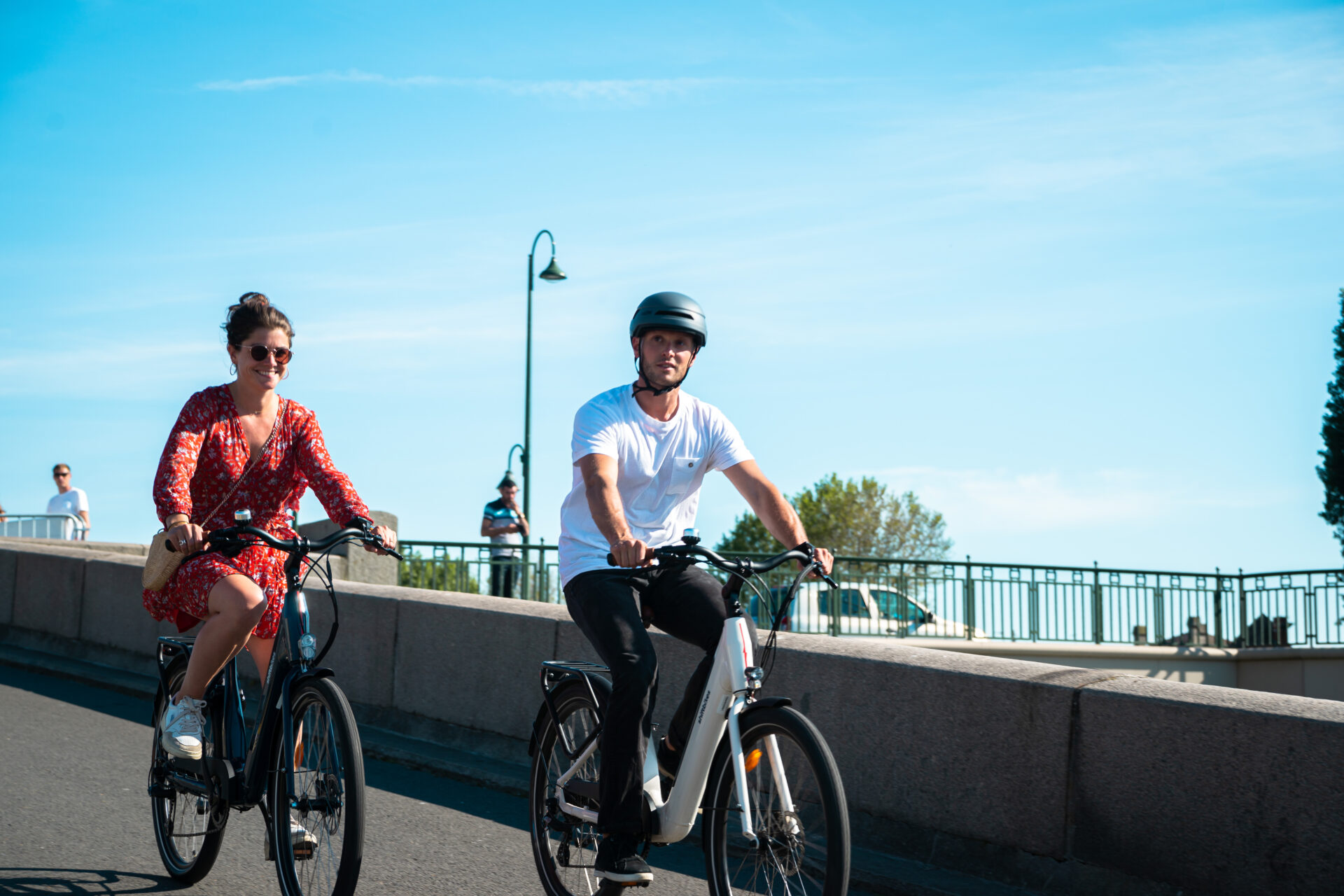 Un couple se ballade à vélo dans Paris au soleil
