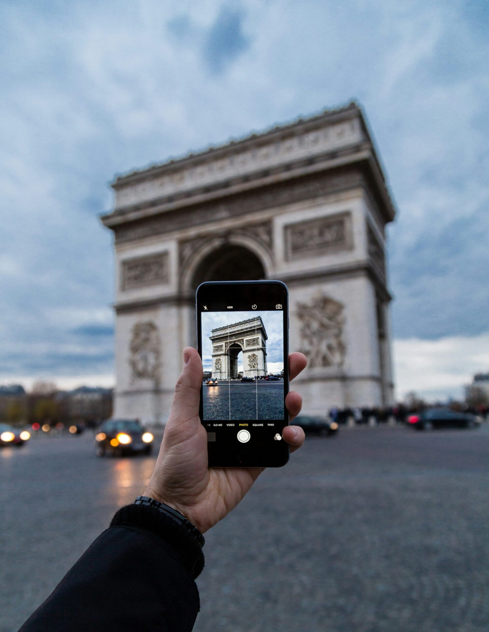 Personne prenant en photo l'arc de triomphe pendant son tour guidé à Paris