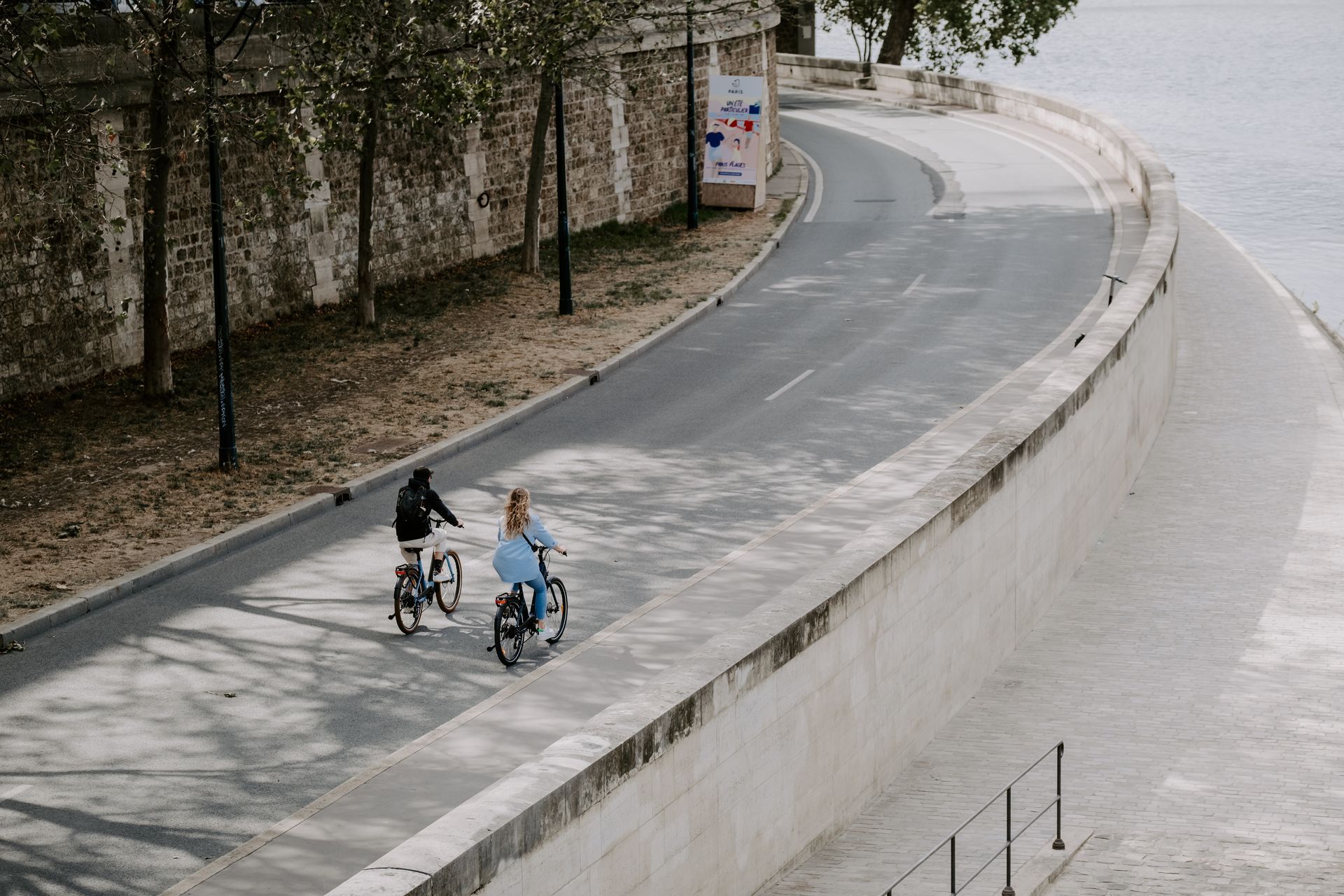 un couple en vélos de location à paris près de la seine