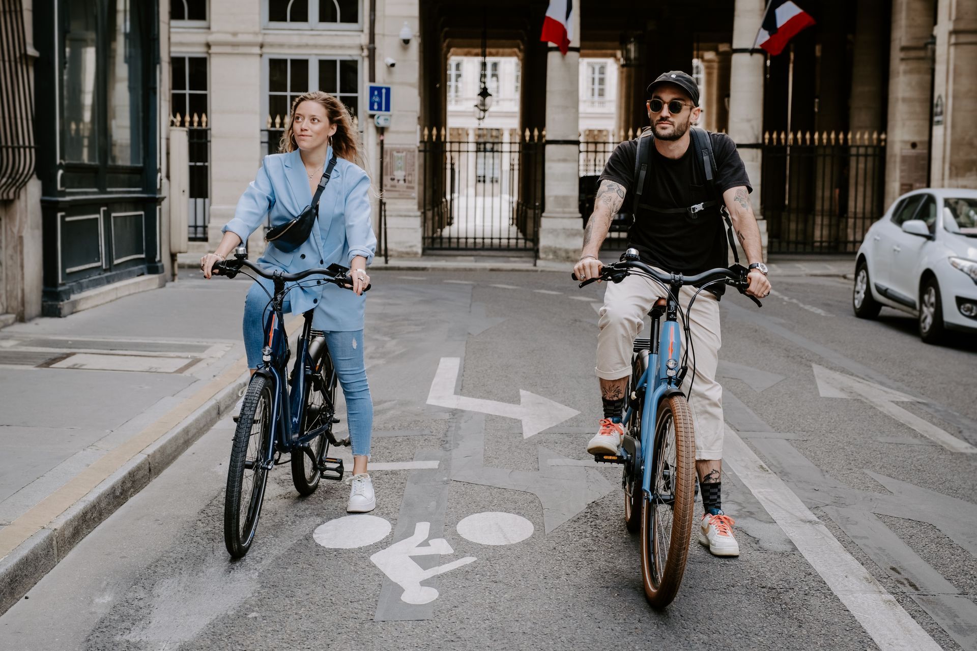 une jeune femme et un jeune homme en balade à vélo de location dans paris